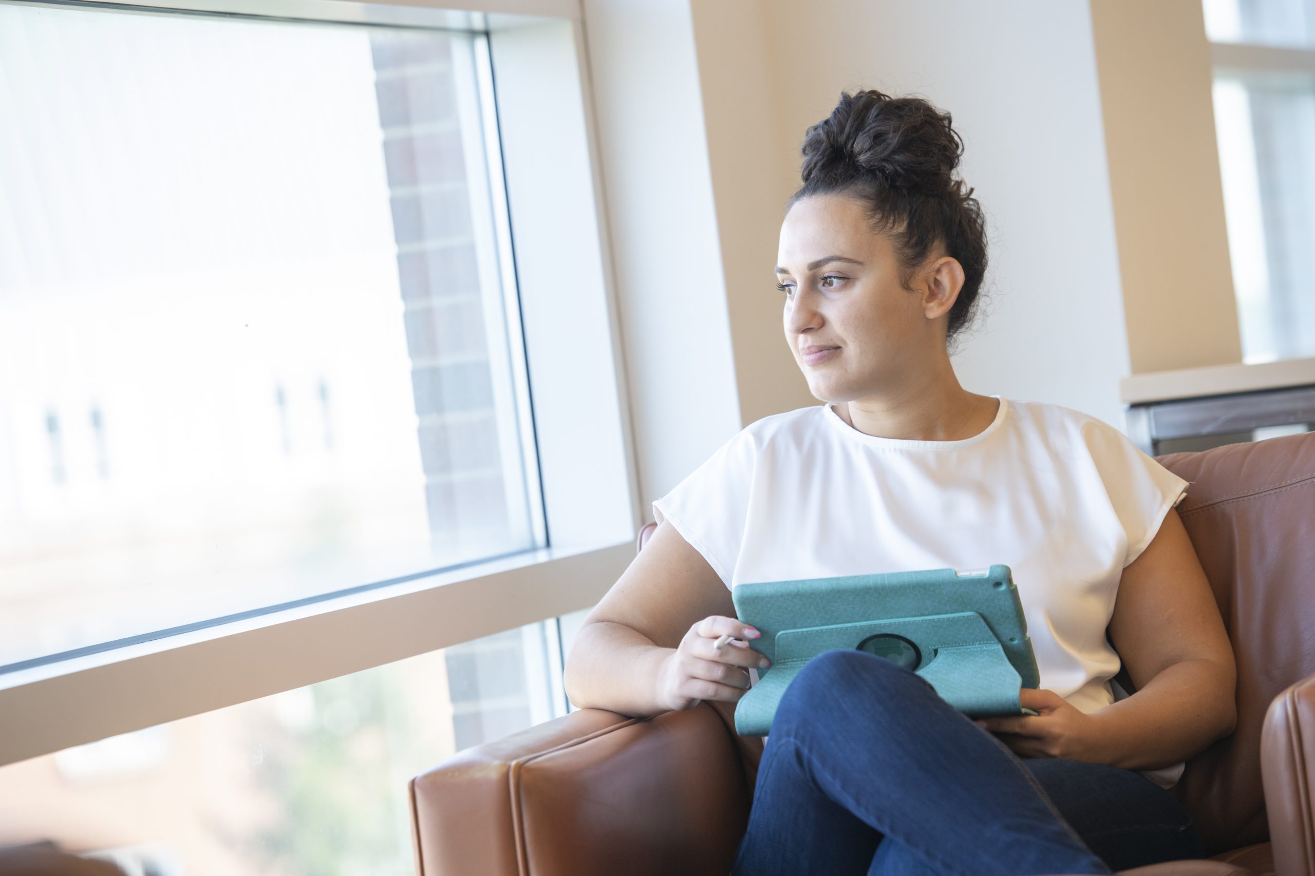 Student with computer looking out the window