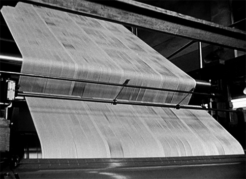 newspapers being printed quickly on a rolling press