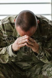 Soldier resting head in hands