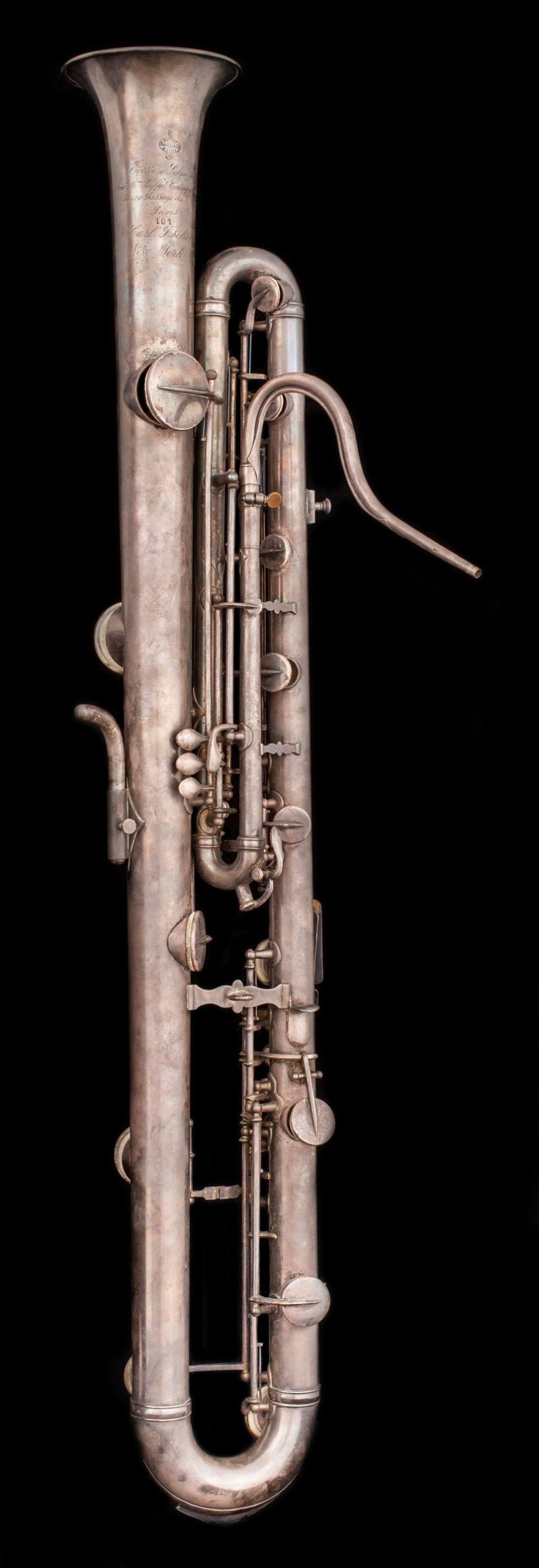 Silver instrument with keys, similar to saxophone, but with bell facing upwards.