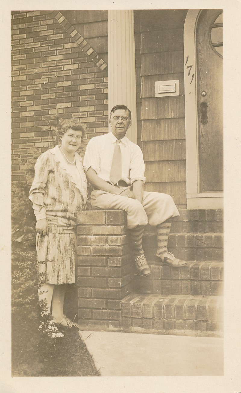 Harlan Hoyt Horner, sitting on edge of porch, next to his wife, Henrietta Calhoun Horner, who is standing. 
