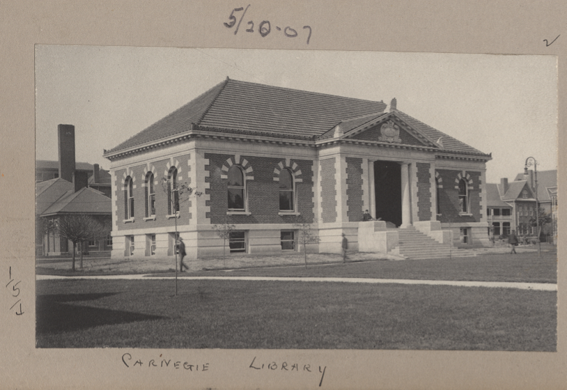 A black and white photograph of a building with an expansive lawn is pasted on a sheet of paper. "5/20'09" is written on top and "Carnegie Library" beneath. 