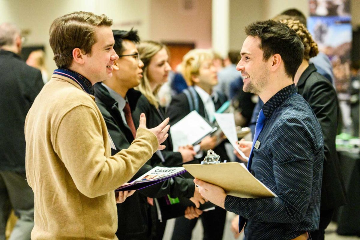 students and alumni interacting at industry event. 