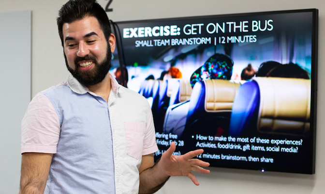 advertising professional standing in front of digital screen talking