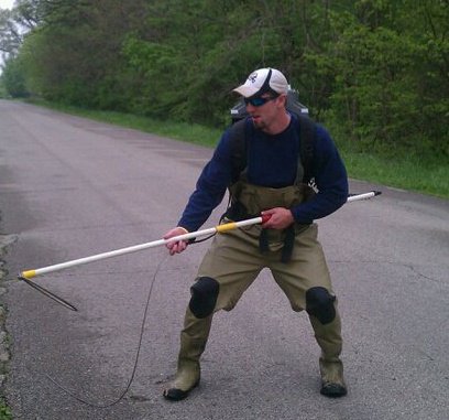 man backpack electroshocking fishes