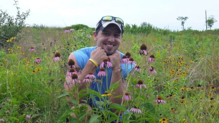 Brandon Cheek crouches amid wildflowers