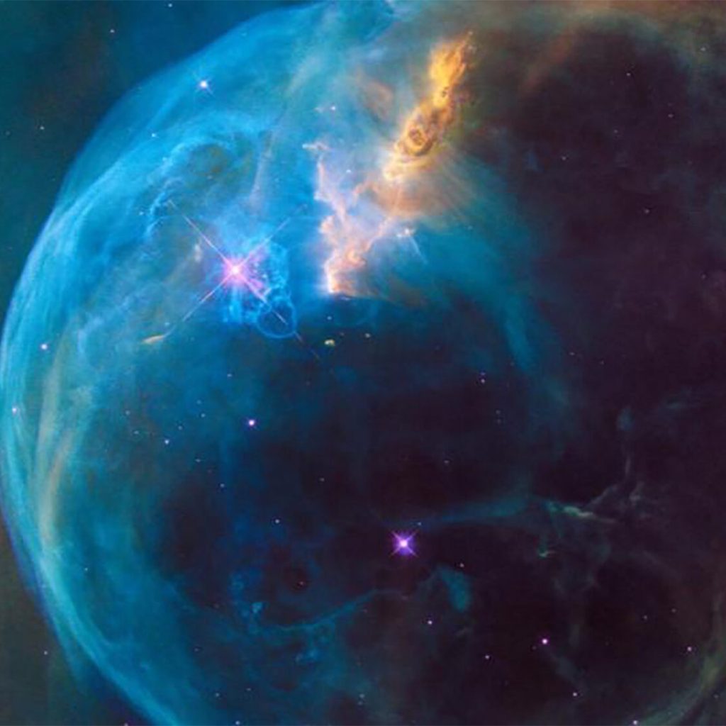 Swirling nebulous orb with shades of blue green and yellow gas clouds