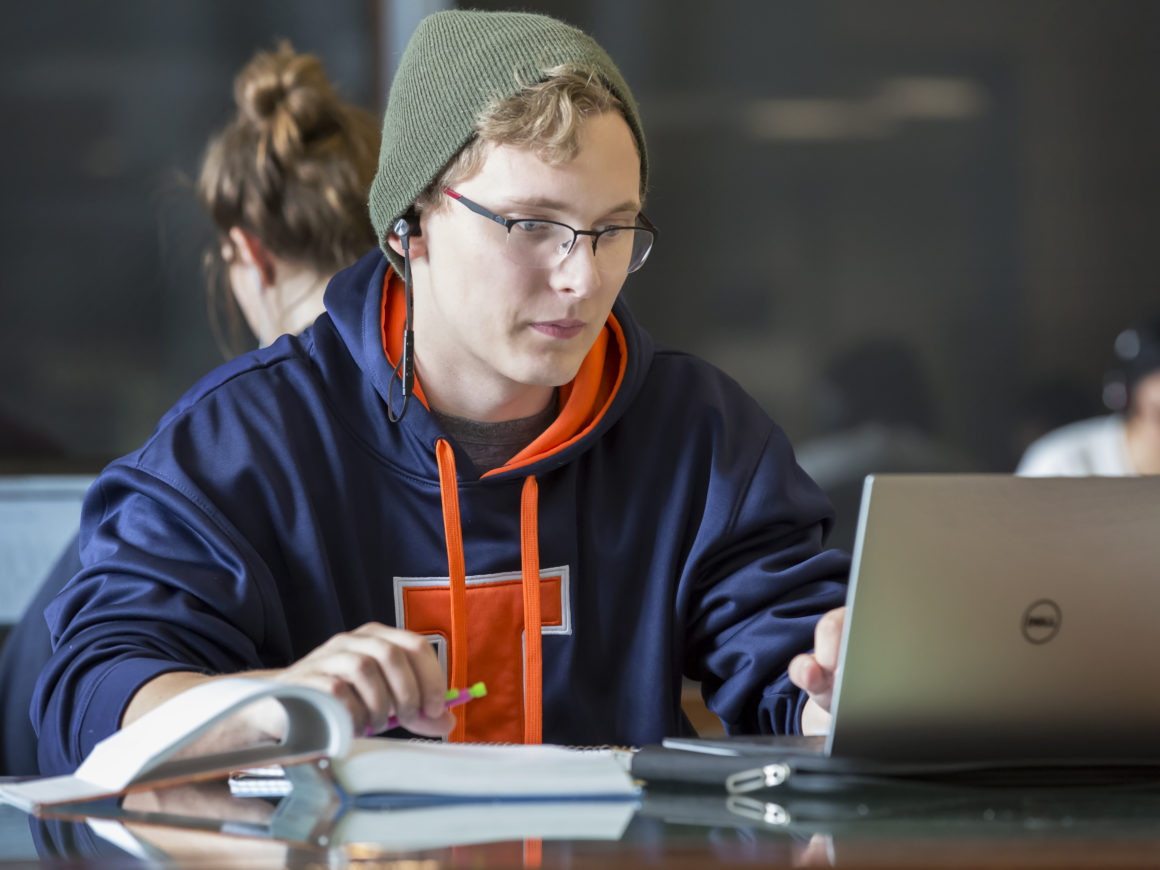 Male student studying with laptop in the Electrical and Computer Engineering Building.