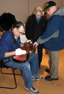 Scott Schwartz examines a violin.