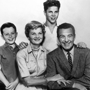 black and white image of the Cleaver family huddled together with arms around each other
