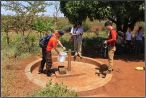 Illinois students filling a bucket from a well