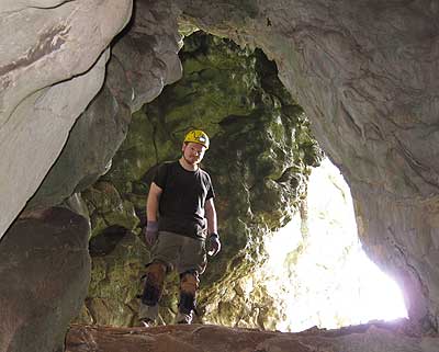 man stands in cave opening