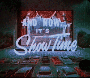 A gif reading "And now.... It's Show Time" over a background drive-in theatre screen. 