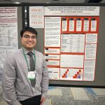 Vinh, a graduate student, standing next to his research poster at the conference.