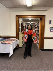 Émilie Songolo holding an African textile from her personal collection