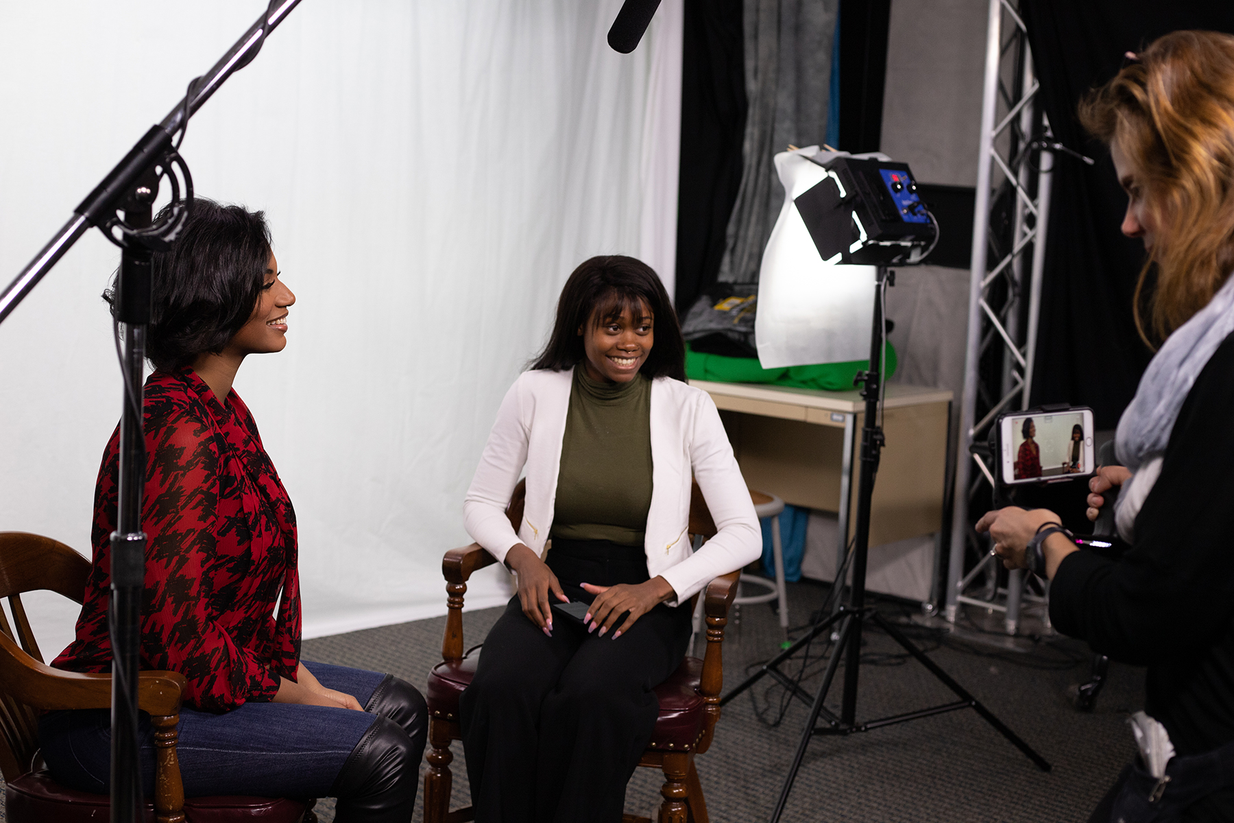 A journalism student interviews journalism alumna Taylor Rooks for a campus feature story.
