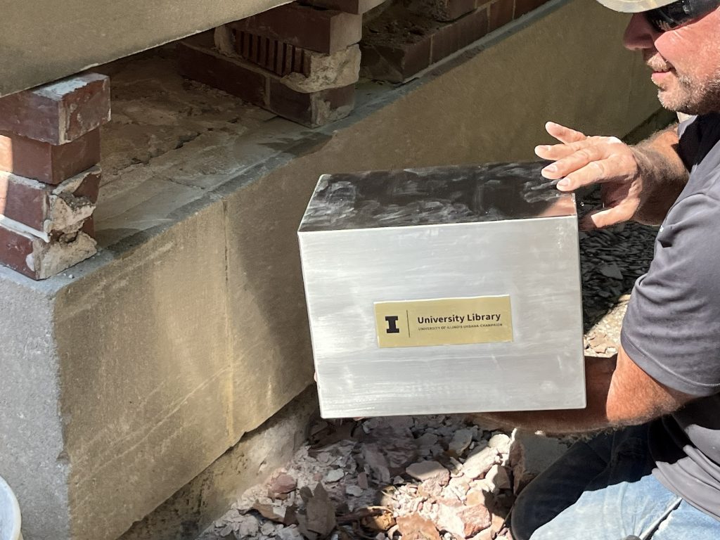 Time capsule being installed in the Main Library's cornerstone