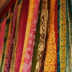 An array of silks hanging on a wall