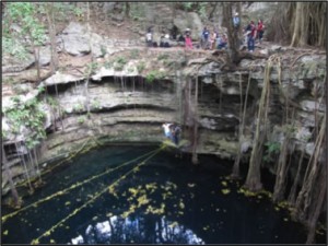 People gathered at the edge of a cenotes.