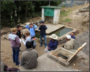 Casually dressed researchers and Mexicans near a well