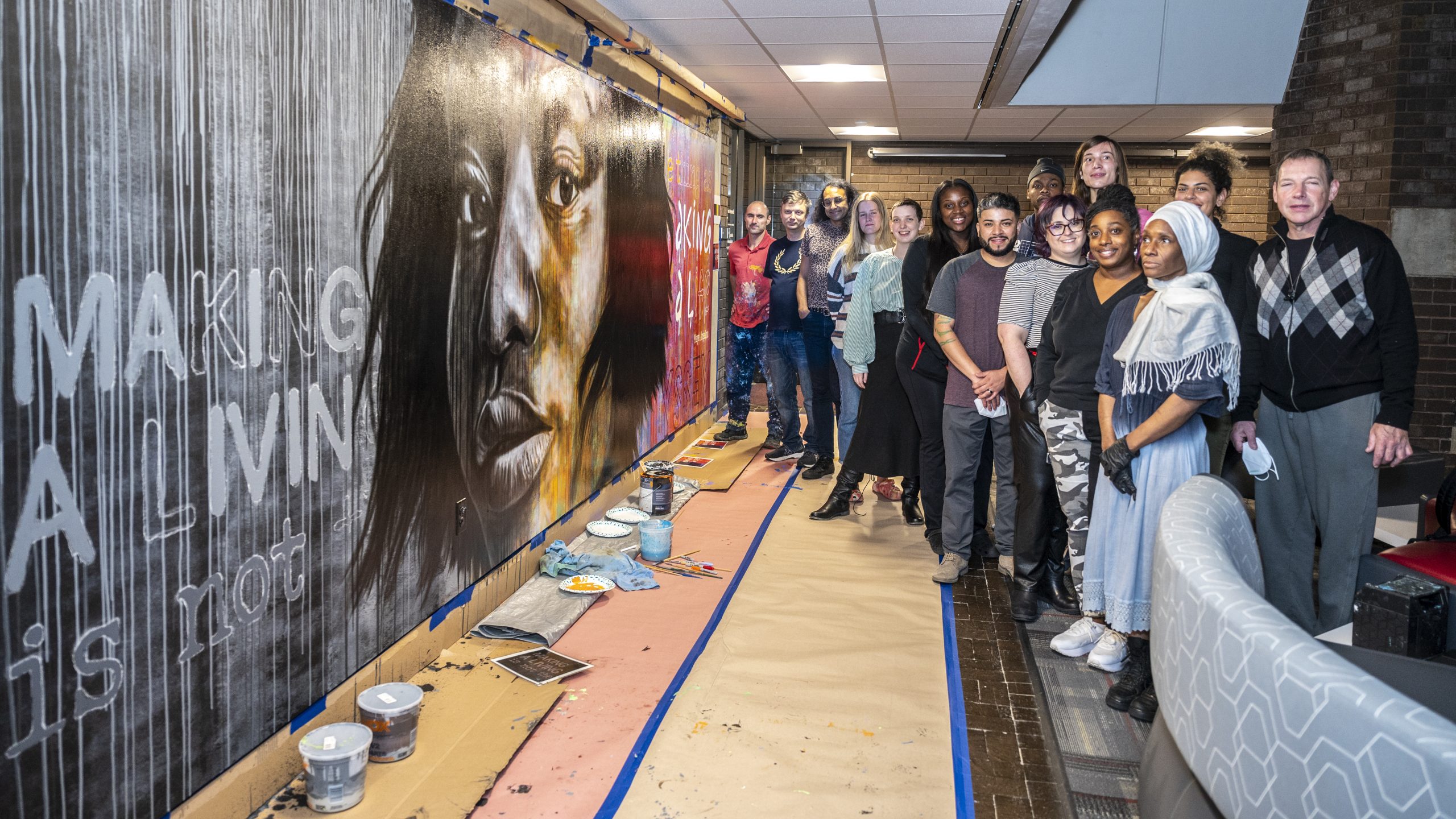 Odyssey Project students standing next to the mural in progress