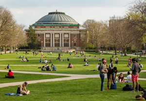 Image of the main quad with students sitting in grass 